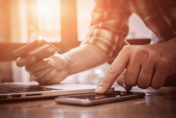 Image of man entering credit card info into mobile phone.