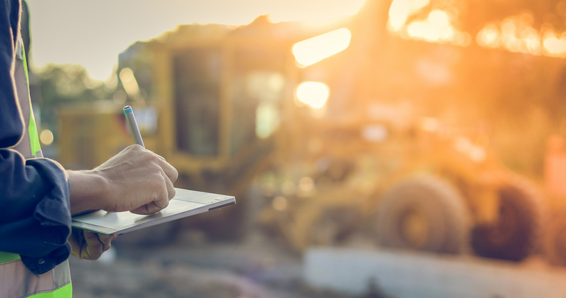 Image of someone taking notes at a construction site.