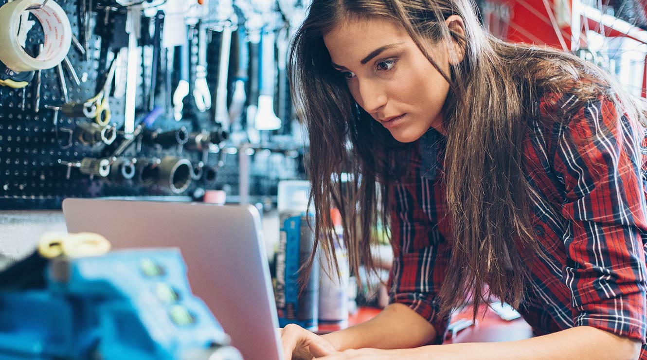 Young woman in a workshop on a computer.